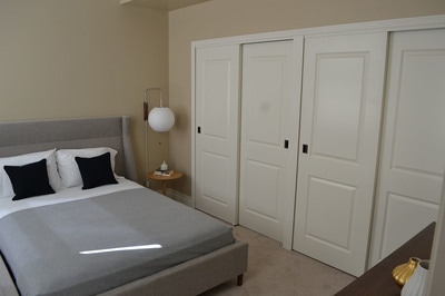 A large bed with a huge double closet next to it