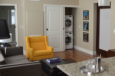 A living room with colorful accents and a hidden washer/dryer